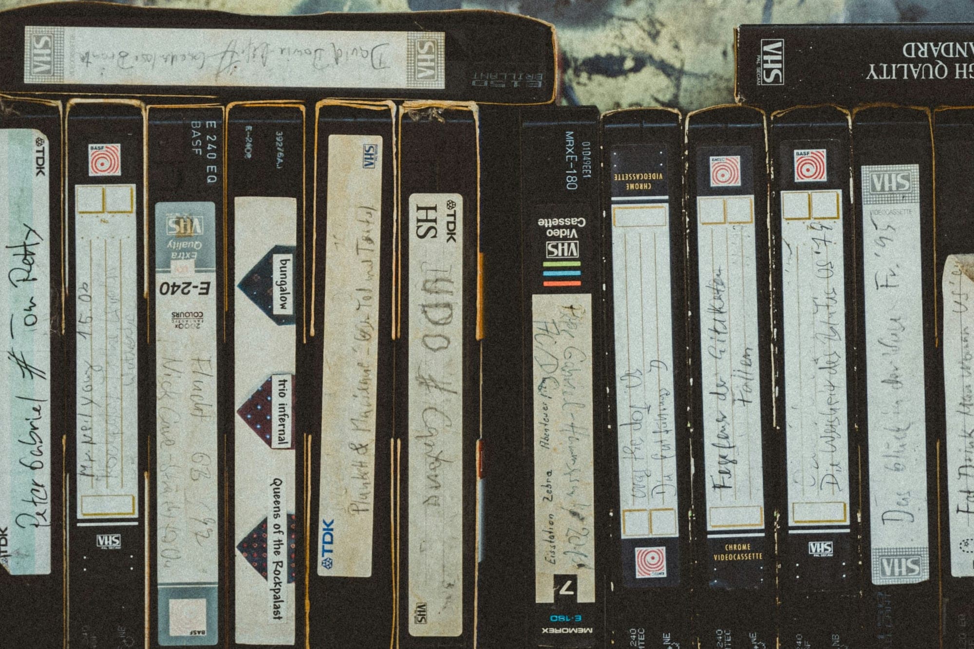 שורה של קלטות וידאו VHS ישנות עומדות זו לצד זו, עם מדבקות שנכתבו ביד